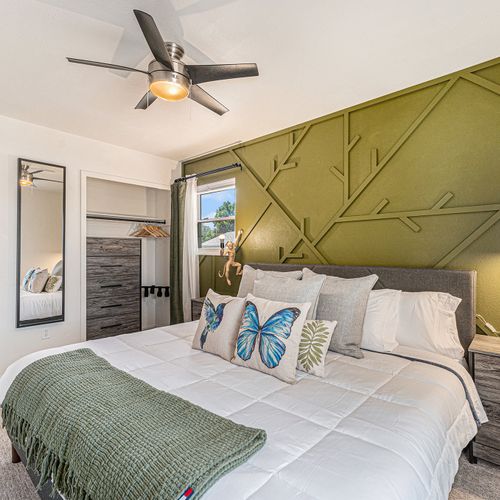 Bedroom 3 showcases army green walls and offers ample storage options, combining style with practicality.