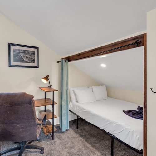 Clean, simply styled bedroom w/ a classic headboard & soft natural light.