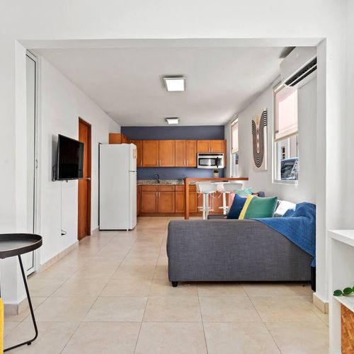 A chic and comfortable space. Our living room is designed for both style and function, with a TV for entertainment and a large mirror to open up the room.
