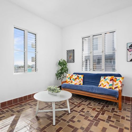 This living room features a versatile futon that can be used as a couch or a bed.
