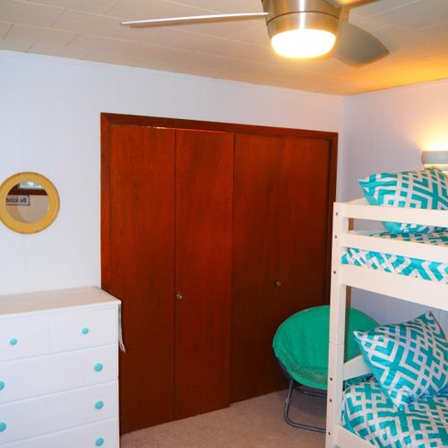 Bedroom #2:  features a full-size bed, bunk bed (i. E. 2 single beds on top of each other), ceiling fan, dresser, mirror, and closet.