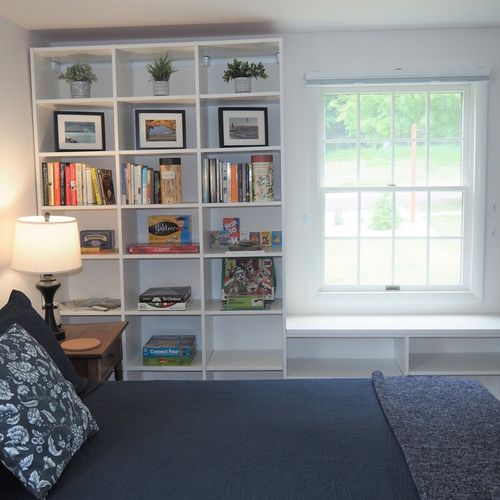 Bedroom #2 (main floor):  large and lovely bedroom with a queen-size bed, rocking chair, nightstands with lamps, two bookcases, a dresser, and a wardrobe.