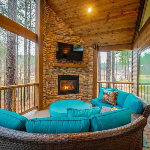 The covered deck with outdoor seating and a fireplace.