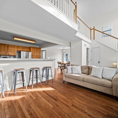 Bright living space with comfortable seating and open connection to kitchen bar