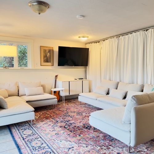 Stretch out in this spacious lounge with plenty of seating for everyone. Watch a movie, play games, or relax with music after a full day out—soft sofas, a large TV, and a cozy rug make it an easy place to unwind together.