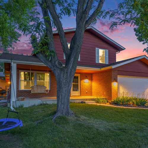 At dusk, the front of the house becomes a magical scene, with the tree swing hanging invitingly, ready for laughter-filled moments and carefree swinging under the enchanting twilight sky.