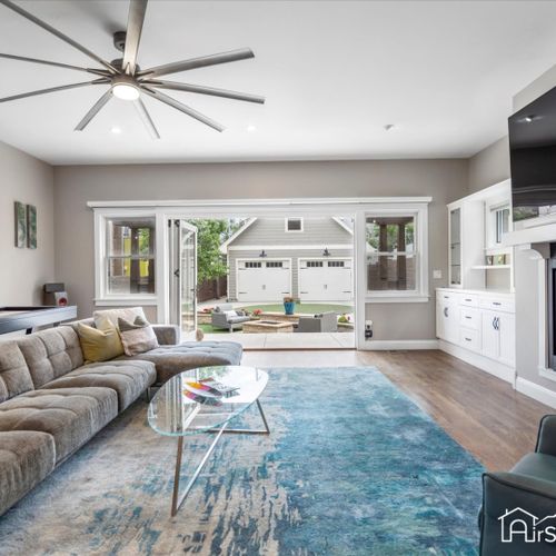 The large and bright family room features a gas fireplace, custom built-in shelving and ample seating.