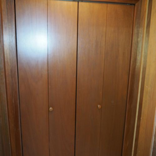 Hallway:  large storage closet at end of hallway with a vacuum cleaning, high chair, and laundry basket.