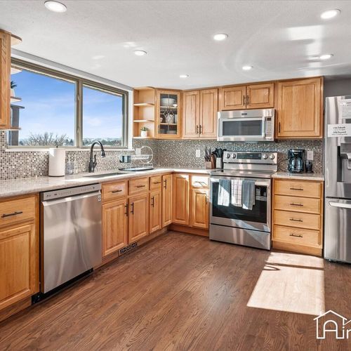- fully equipped kitchen featuring wood cabinetry, stainless steel appliances, & hood
- mosaic tile backsplash adds texture while windows bring in fresh morning light
- extra counter space makes this kitchen ideal for home cooked meals & gatherings