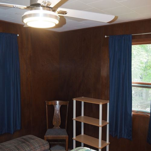 Bedroom #1:  features a queen-size bed, dresser, chair, lamps, and a ceiling fan.