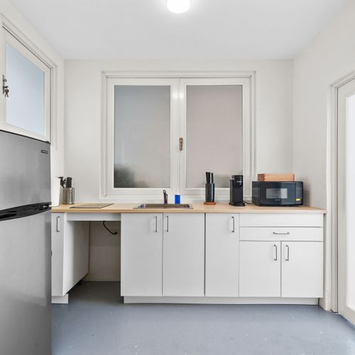 Fully stocked kitchen with a refrigerator, sink, and microwave to prepare your meals.