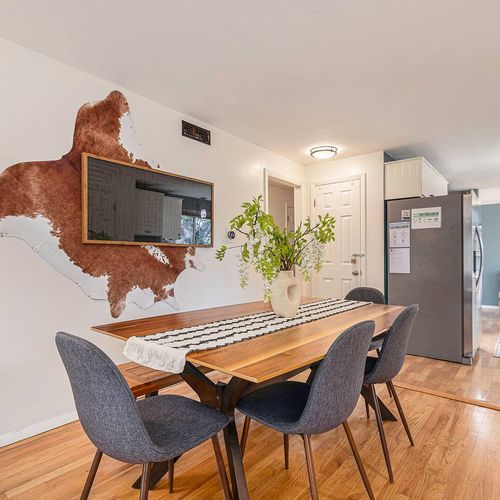 - modern dining room with a live edge wood table, seating for six, and a bold wall art display
- bright and airy with natural light and stylish decor accents
- great for family meals, game nights, or remote working
