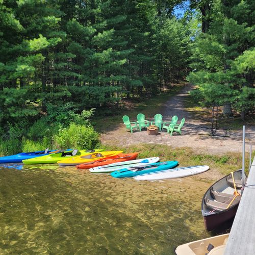 Exterior:  another view of the private lakefront showing the dock, pedal boat, canoe, kayaks, paddleboats, and bonfire ring.