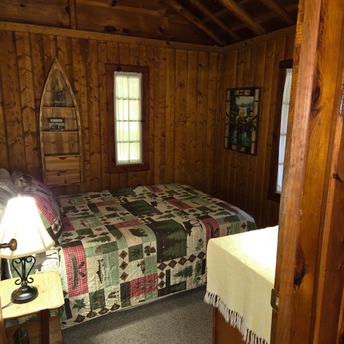 Bedroom #2:  this bedroom is at the front of the cabin from off the living room and features a full-size bed, nightstand, lamp, dresser, mirror, and closet.