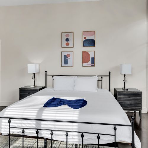 Sprawling bed dressed in crisp white linens w/ a bold modern headboard.