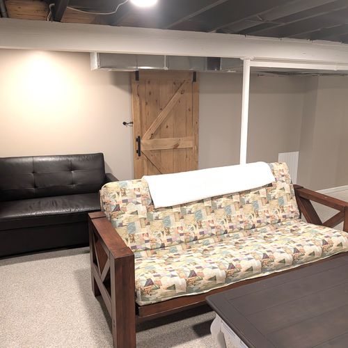 LIVING ROOM #3 (LOWER LEVEL):  Very fun third living room / game room in the basement with a futon, loveseat, coffee table, electric fireplace, and large screen smart television with live streaming. Note that this room is not to be used for sleeping.