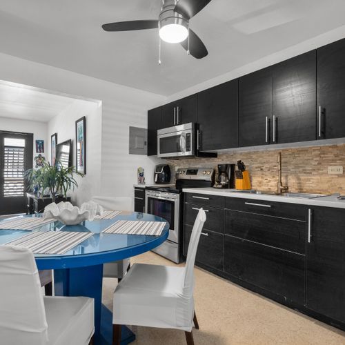 Culinary Delights Await: Our fully-equipped, modern kitchen with an inviting island and seating is perfect for preparing delicious meals and enjoying morning coffee.