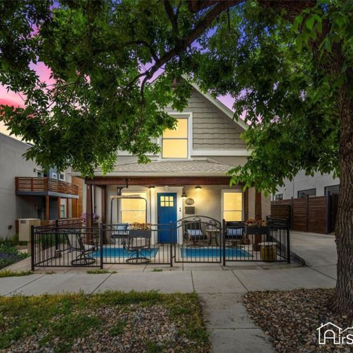 A stunning dusk photo of the front of the home, showcasing its elegant exterior illuminated by warm lights.