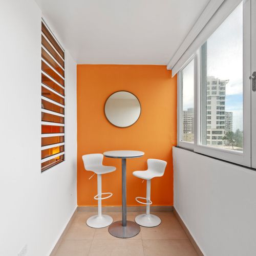 Beautifully framed by panoramic ocean views and vibrant orange walls.