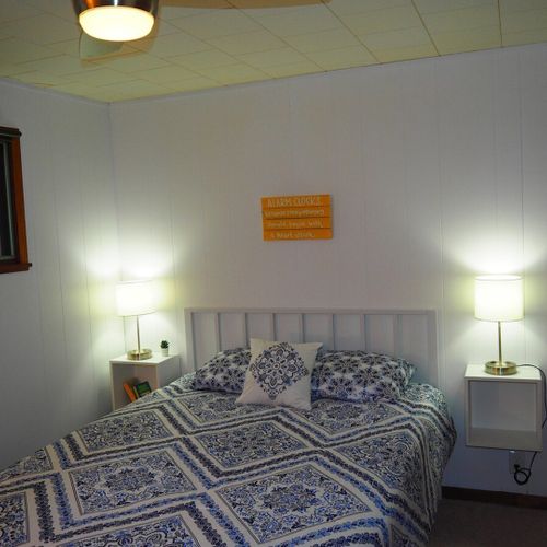Bedroom #1:  features a queen-size bed, nightstands with lamps, ceiling fan, chair, dresser, closet, and full-length mirror.