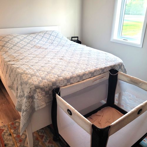 BEDROOM #2:  Features a queen-size bed, crib, ceiling fan, closet, nightstands, lamp, mirror, and a private desk and television