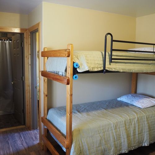 Main room:  includes two twin-on-twin bunk beds, a small dining table, chairs, and a kitchenette / sink.