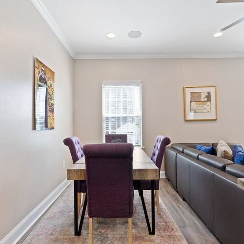 Dining table tucked behind the couch — seats 4 for easy meals together.