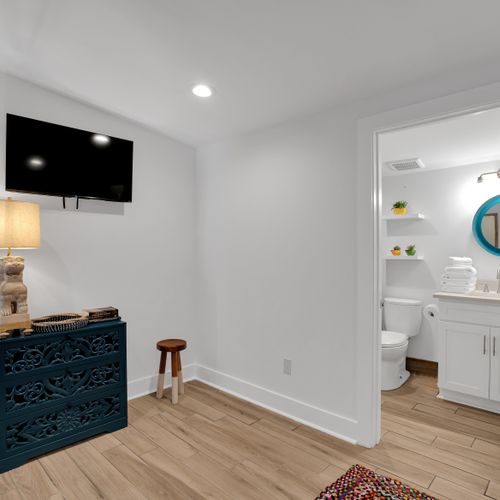 Bedroom 2 w/ a wall-mounted TV & clean white walls for a calm, comfortable stay.