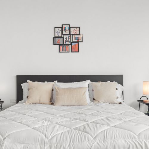Minimalist elegance in a bedroom that's a blend of comfort, style, and tranquility, complete with inspiring art.
