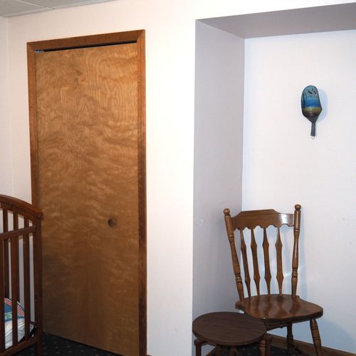 Bedroom #2 (lower level):  features a king-size bed, dresser, chair, table, and crib.