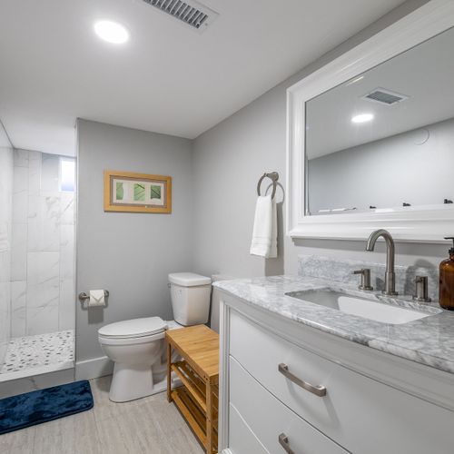 The basement bathroom is reminiscent of a spa with a large newly tiled walk-in shower.