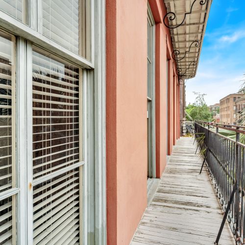 Private balcony w/ wrought-iron railings & lush palm tree views.