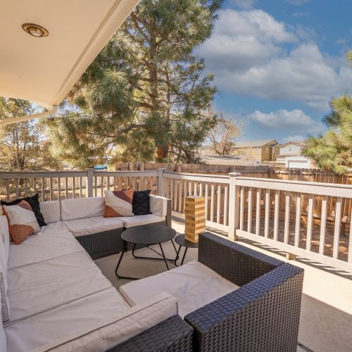 Relax in the sunny outdoor area with a comfy couch and fresh, inviting vibes.