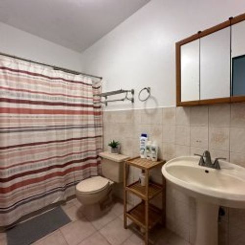 Freshen up in our sleek and modern bathroom, featuring a stylish wall mirror, a refreshing shower, a convenient sink, and a WC, all designed for your comfort and convenience.