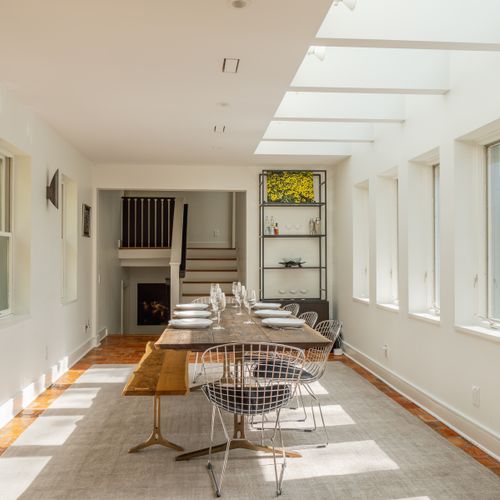 Looking from the kitchen into the spectacular dining room, with wall-to-wall windows and skylights.
