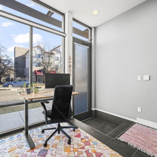 Warm, bright workspace with large windows, fast wi-fi, a standing desk, and an ergonomic chair with monitor—ideal for comfortable, focused work.