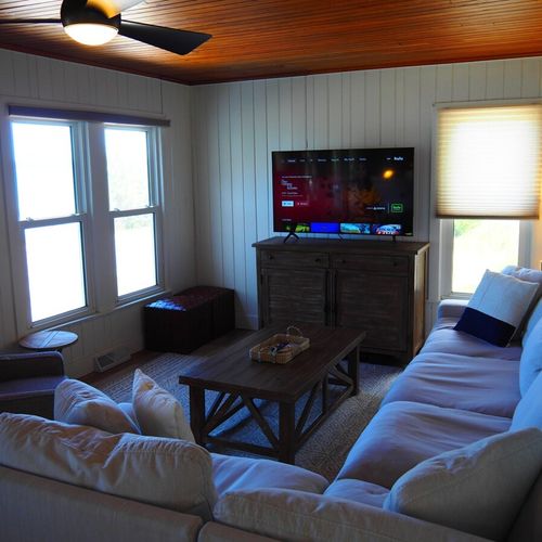 Living room:  the home has a very comfy living room with all new furniture, a ceiling fan, great views of crystal lake, a game table, and a wood-burning fireplace!