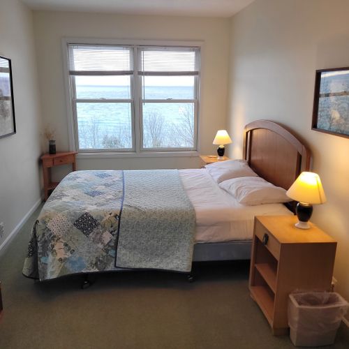 Bedroom #4 (upper level):  very large bedroom featuring a queen-size bed, credenza, ceiling fan, closet, chair, and great views of lake michigan!