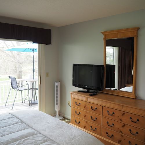 Guest bedroom:  features a queen-size bed, private entrance from the deck, nightstands with lamps, a dresser, closet, chair, and its own television.