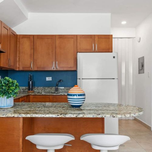 Prepare delightful meals in a kitchen adorned with rich wooden textures, complemented by an inviting breakfast bar.