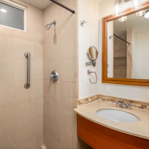 Refresh and rejuvenate in our clean, contemporary bathroom featuring a spacious shower and elegant vanity.