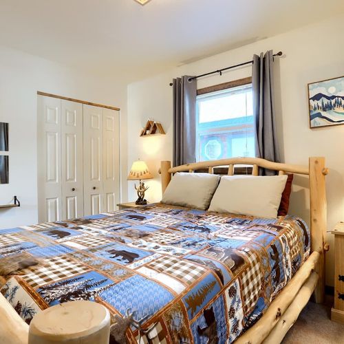 - snuggle into a handcrafted log bed topped with soft pillows and charming wildlife quilt
- rustic nightstands and antler lamps create the perfect mountain lodge feel
- wake up to warm natural light and peaceful pine views just beyond your window
