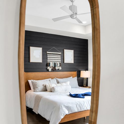 A modern retreat with a stylish dark accent wall and plush bedding for a restful night.