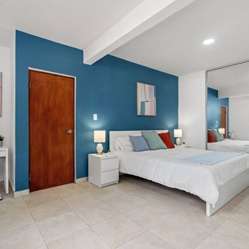 Experience the elegance of our stylish room, featuring a luxurious  bed and a mirror.