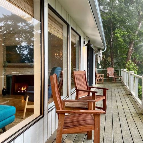 Balcony seating amongst the trees, clouds and water.