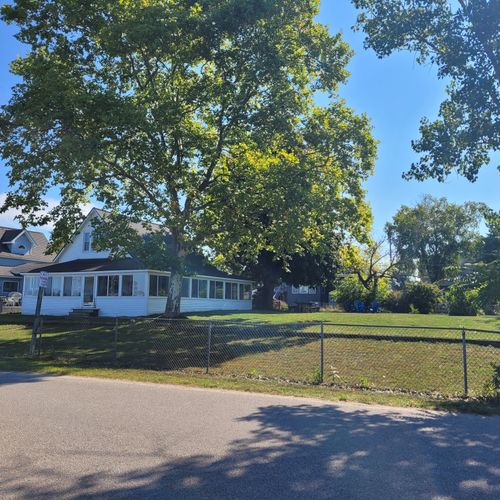 EXTERIOR:  Looking at the property from Lake Street, highlighting the large and fully fenced-in yard.