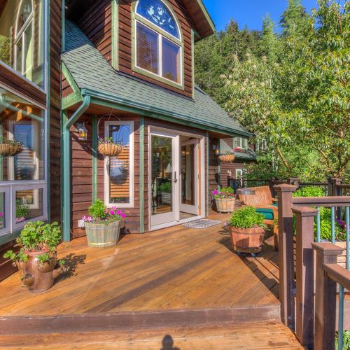 Decks outside of the dining room with Madrona Trees, lilacs and water views.