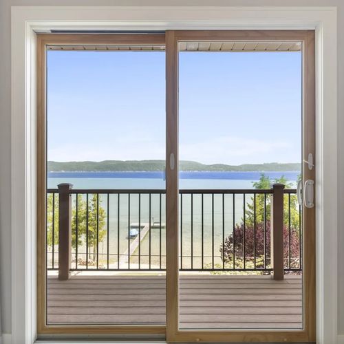 PRIMARY BEDROOM (UPPER LEVEL):  The sliding doors going out to the private balcony and the incredible view of Crystal Lake from the bedroom