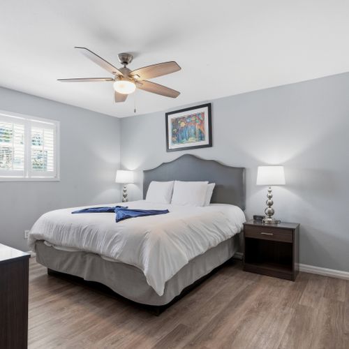 Serene primary bedroom w/ a plush bed & calm grey tones for restful nights.