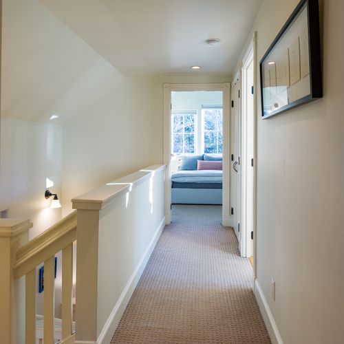 A bright and airy hallway connecting the upstairs rooms with natural light throughout.